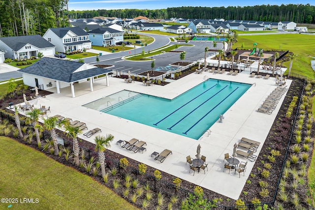 pool featuring a patio, fence, and a residential view