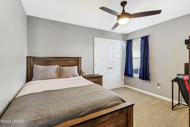 bedroom featuring ceiling fan, baseboards, a closet, and light colored carpet