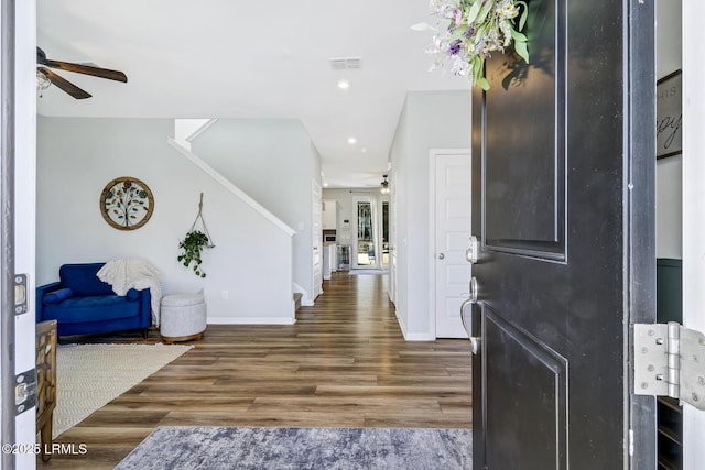 foyer entrance with ceiling fan, wood finished floors, visible vents, baseboards, and stairway