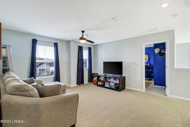 living area with carpet floors, visible vents, ceiling fan, and baseboards