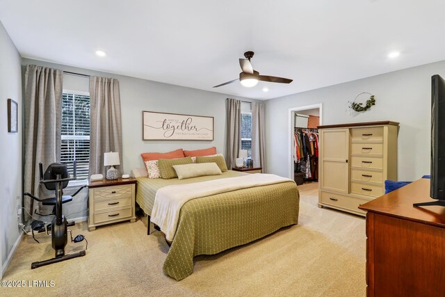 bedroom featuring recessed lighting, light colored carpet, a ceiling fan, a spacious closet, and a closet