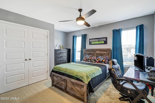 carpeted bedroom with a closet, multiple windows, and ceiling fan