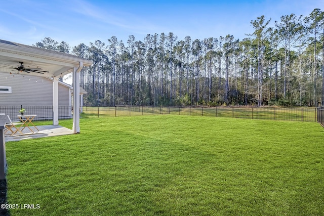 view of yard featuring fence, a ceiling fan, and a patio