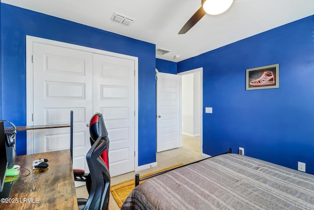 carpeted bedroom with ceiling fan, a closet, visible vents, and baseboards