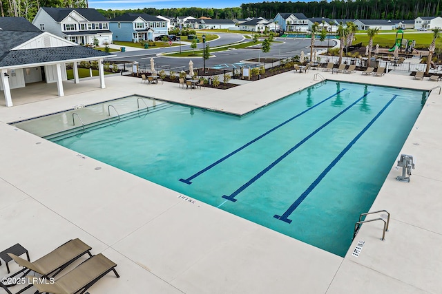 pool with a patio area and a residential view