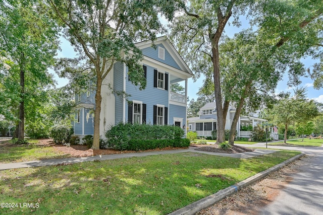 neoclassical / greek revival house with a balcony and a front yard