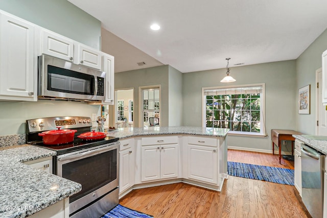 kitchen featuring light stone countertops, appliances with stainless steel finishes, pendant lighting, and white cabinets