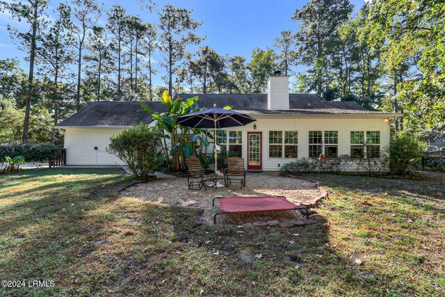 rear view of house featuring a yard and a patio area