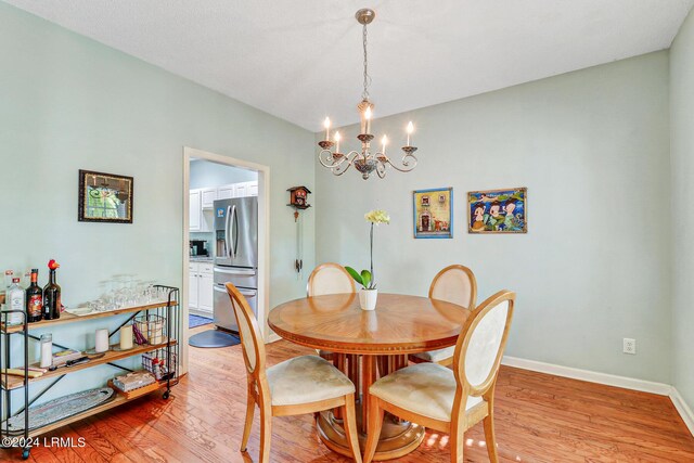 dining room with a notable chandelier and light hardwood / wood-style flooring