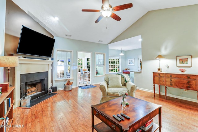 living room featuring ceiling fan, high vaulted ceiling, and light wood-type flooring