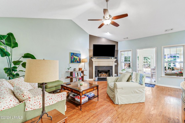 living room featuring lofted ceiling, ceiling fan, and light wood-type flooring