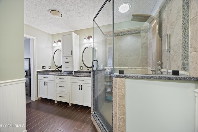 18 Lake View Ct, Bluffton, SC 29910 - full bath featuring a stall shower, double vanity, wood finished floors, a textured ceiling, and wainscoting