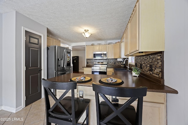 18 Lake View Ct, Bluffton, SC 29910 - kitchen with appliances with stainless steel finishes, dark countertops, a sink, light brown cabinets, and tasteful backsplash