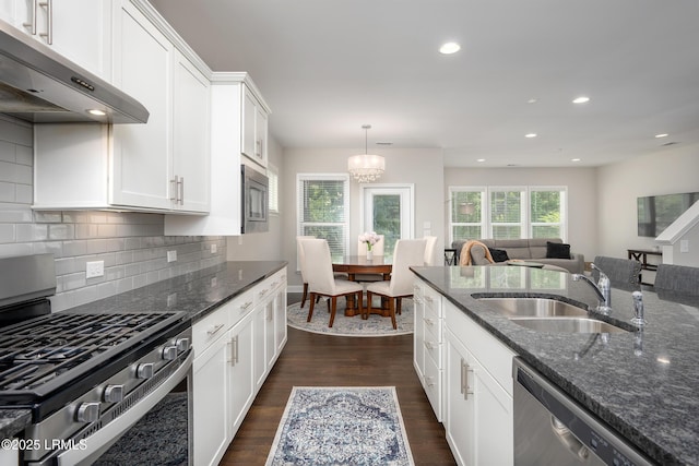 145 Rudder Run, Bluffton, SC 29910 - kitchen with appliances with stainless steel finishes, under cabinet range hood, a sink, dark stone counters, and a chandelier
