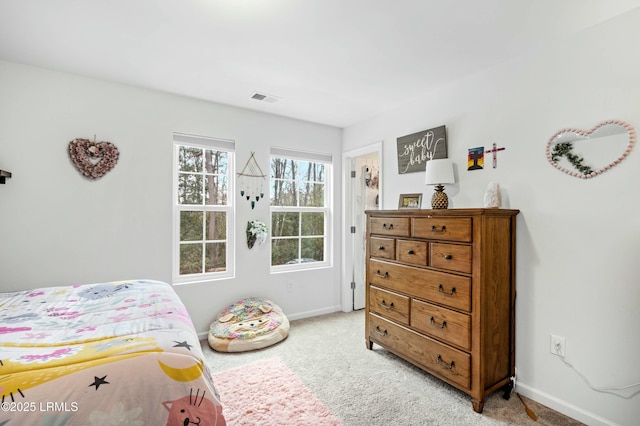 bedroom with baseboards, visible vents, and light colored carpet