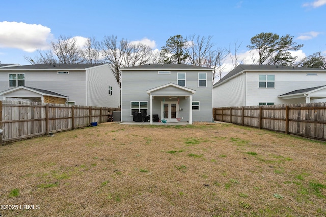 back of property featuring french doors, a fenced backyard, a yard, and a patio