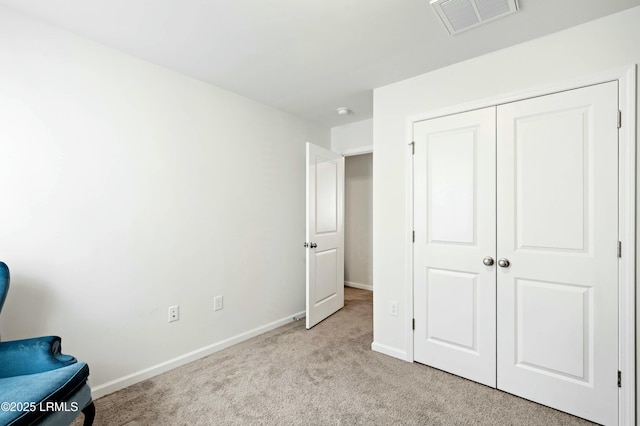 unfurnished bedroom featuring carpet, a closet, visible vents, and baseboards