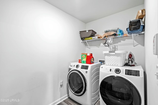 laundry area with laundry area, wood finished floors, washing machine and clothes dryer, and baseboards