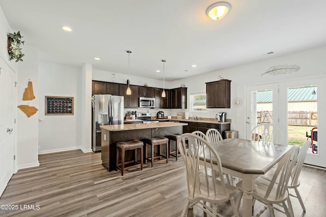 dining room featuring baseboards, light wood finished floors, visible vents, and recessed lighting