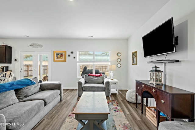 living room featuring french doors, wood finished floors, visible vents, and baseboards