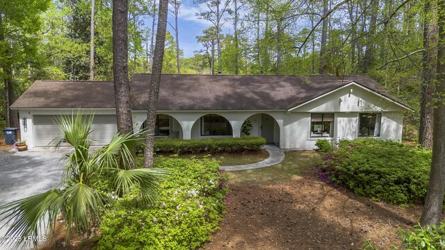 view of front of house with concrete driveway, an attached garage, and stucco siding