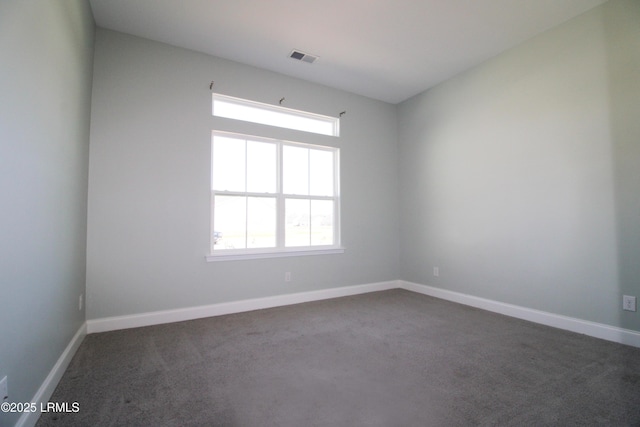 unfurnished room featuring dark colored carpet and baseboards