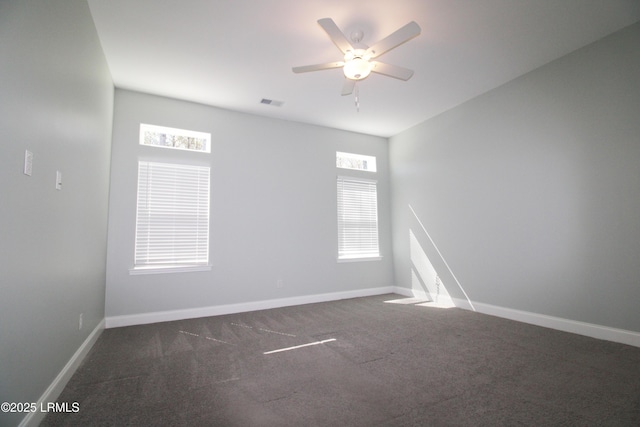 carpeted empty room featuring visible vents, baseboards, and a ceiling fan