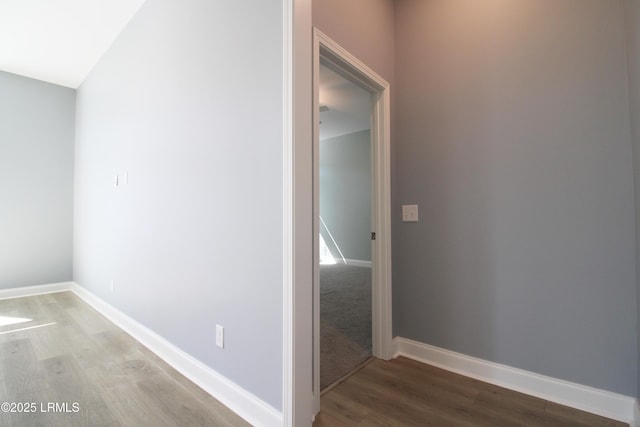 hallway featuring wood finished floors and baseboards