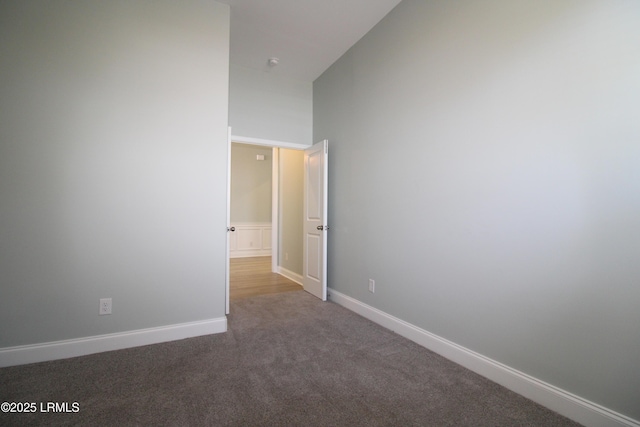 carpeted spare room featuring baseboards