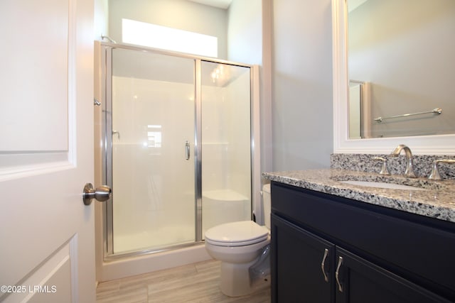 bathroom featuring a stall shower, vanity, and toilet