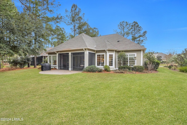 rear view of property featuring a yard, a sunroom, and a patio