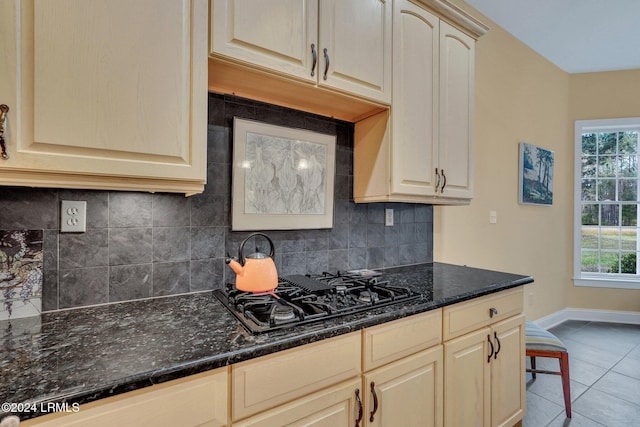 kitchen featuring tile patterned floors, black gas cooktop, decorative backsplash, and dark stone counters