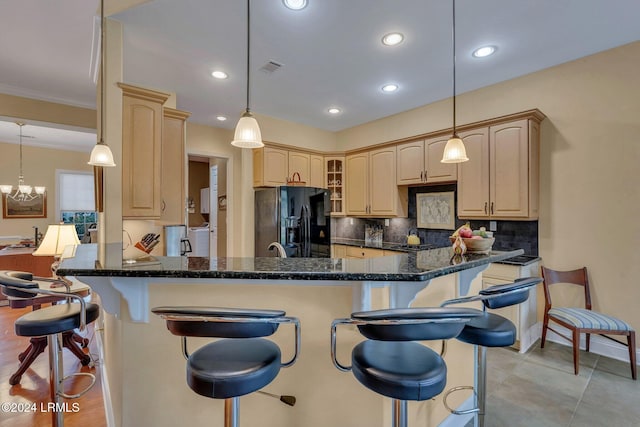 kitchen with pendant lighting, a kitchen breakfast bar, and black fridge with ice dispenser