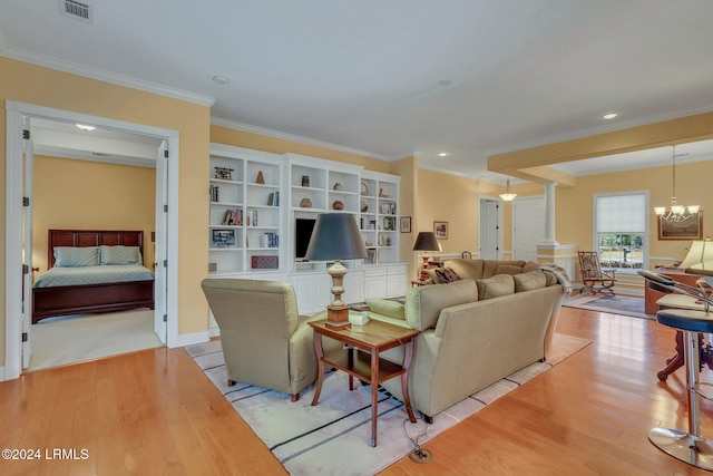 living room featuring decorative columns, crown molding, an inviting chandelier, and light hardwood / wood-style flooring