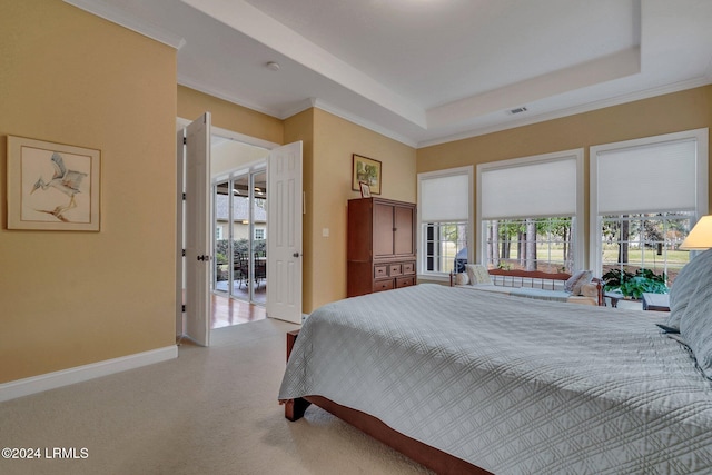 bedroom with a tray ceiling and light carpet