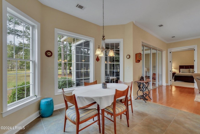 dining space featuring ornamental molding and light tile patterned floors