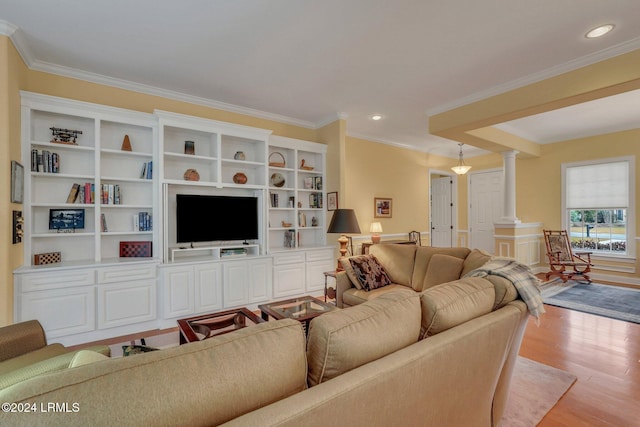 living room featuring crown molding, light hardwood / wood-style flooring, and ornate columns