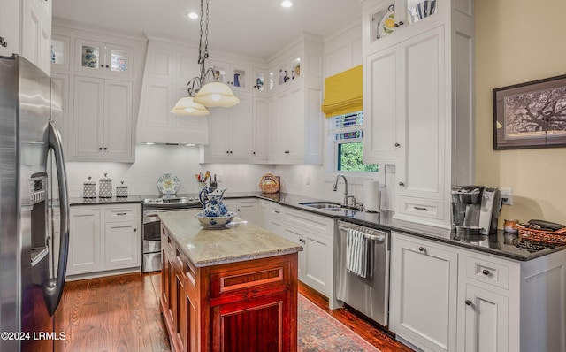 kitchen with sink, a center island, hanging light fixtures, appliances with stainless steel finishes, and white cabinets