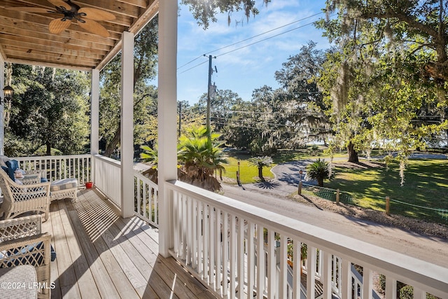 deck featuring a lawn, ceiling fan, and covered porch