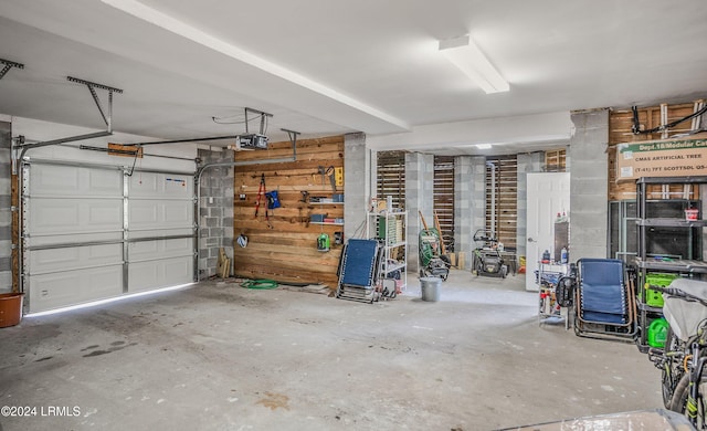 garage with a garage door opener and wooden walls