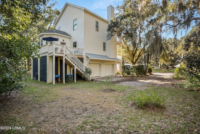 rear view of house with a garage and a deck