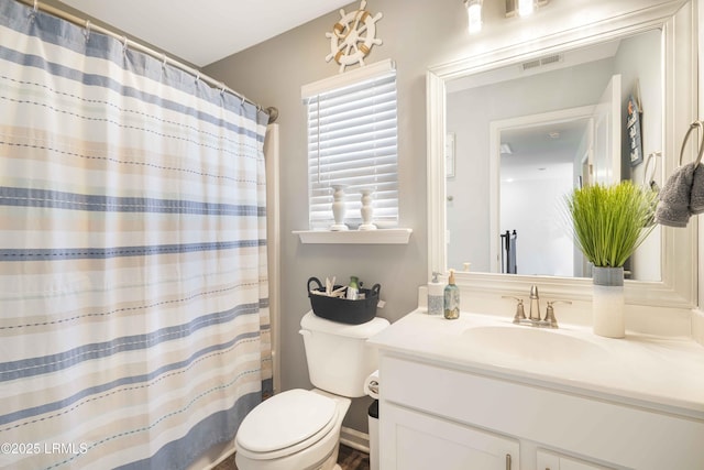 bathroom featuring walk in shower, vanity, and toilet