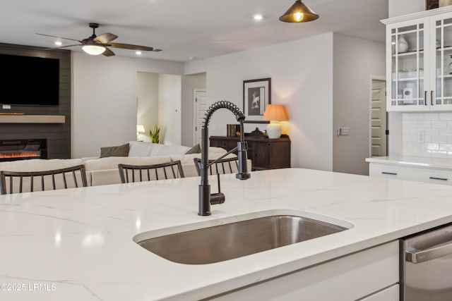 kitchen featuring tasteful backsplash, sink, dishwasher, and white cabinets