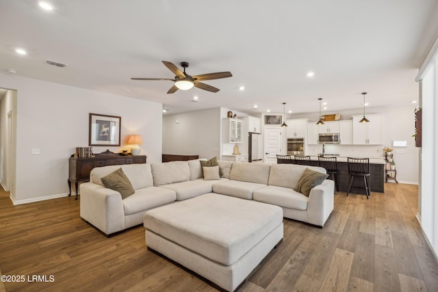 living room with wood-type flooring and ceiling fan