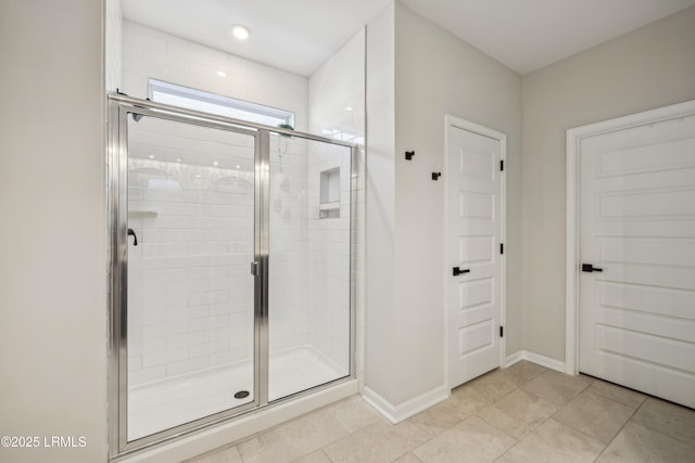 bathroom with an enclosed shower and tile patterned floors