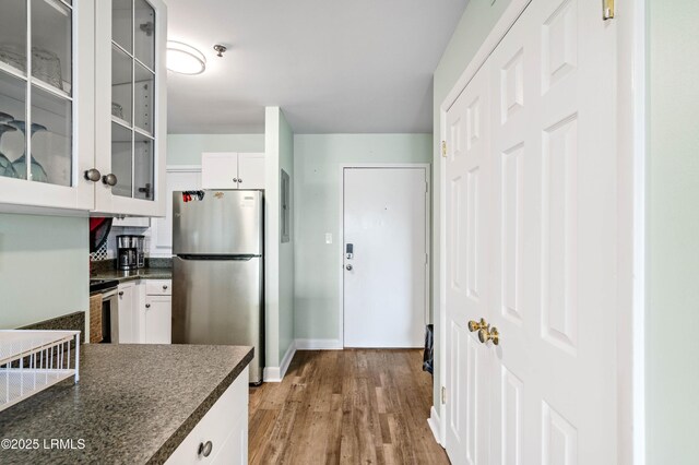 663 William Hilton Pkwy Unit 3404, Hilton Head Island, SC 29928 - kitchen featuring appliances with stainless steel finishes, dark countertops, glass insert cabinets, and white cabinetry