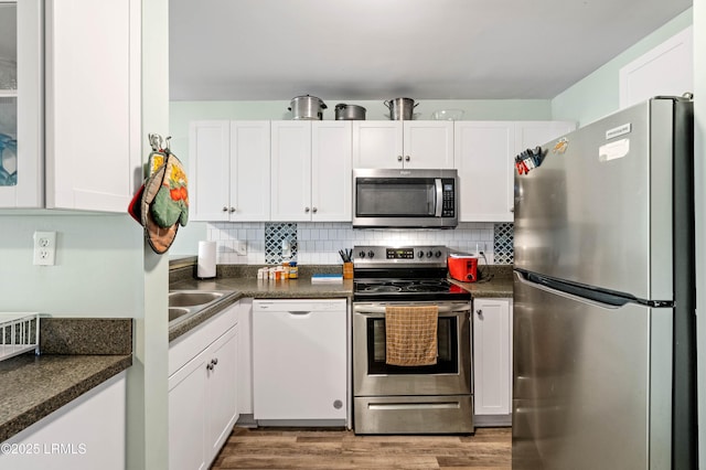 663 William Hilton Pkwy Unit 3404, Hilton Head Island, SC 29928 - kitchen with appliances with stainless steel finishes, dark countertops, white cabinetry, and wood finished floors
