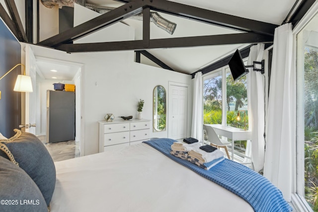 bedroom with vaulted ceiling with beams and freestanding refrigerator