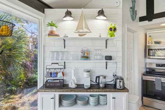 kitchen featuring dark countertops, white cabinetry, appliances with stainless steel finishes, and open shelves