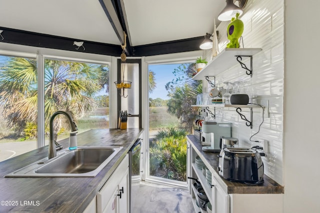 kitchen featuring a healthy amount of sunlight, white cabinetry, open shelves, and a sink